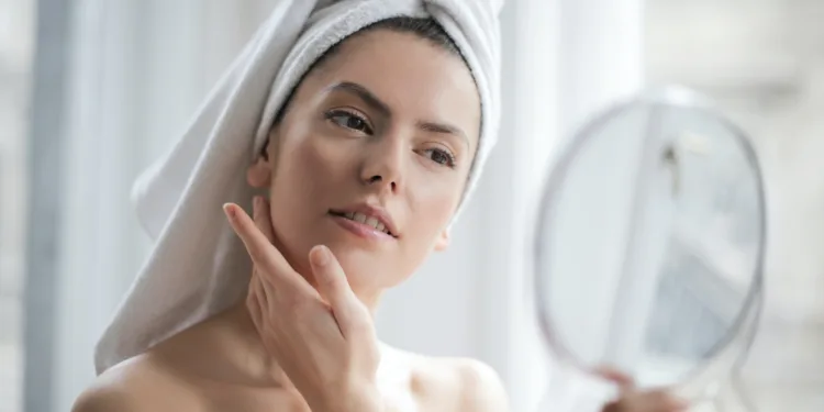 girl applying Korean toners while looking in the mirror