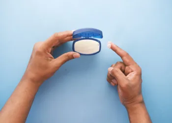 a bit of petroleum jelly being taken out of the container for slugging