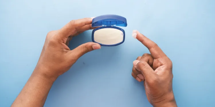 a bit of petroleum jelly being taken out of the container for slugging